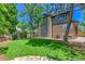 Beautiful backyard with green lawn and brick home, featuring many windows and a covered patio at 11209 Quivas Loop, Denver, CO 80234