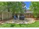 Outdoor patio with stone pavers, wooden fence, and covered grill and seating area at 11209 Quivas Loop, Denver, CO 80234