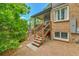 Exterior backyard view of brick home featuring stairs up to covered porch with railing at 11209 Quivas Loop, Denver, CO 80234
