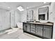 Modern primary bathroom with double vanity, skylight, and glass enclosed shower at 11209 Quivas Loop, Denver, CO 80234