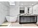 Bright primary bathroom with soaking tub, dual vanity, and modern finishes at 11209 Quivas Loop, Denver, CO 80234