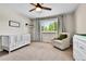 Cozy bedroom with a white crib, comfortable chair, and bright window at 11209 Quivas Loop, Denver, CO 80234
