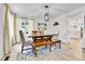 Bright dining room with wooden table, bench, and chairs, complemented by stylish light fixture and artwork at 11209 Quivas Loop, Denver, CO 80234