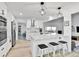 Modern white kitchen with stainless steel appliances, quartz countertops, and an island with seating at 11209 Quivas Loop, Denver, CO 80234