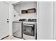 Modern laundry room with stainless steel washer and dryer and woven baskets on the shelf at 11209 Quivas Loop, Denver, CO 80234