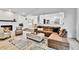 Open concept living area with hardwood floors, comfortable sofa, fireplace, and seamless flow to dining area at 11209 Quivas Loop, Denver, CO 80234