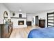 Comfortable bedroom with painted brick fireplace, wood floors, and natural light at 11209 Quivas Loop, Denver, CO 80234