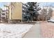 Exterior view of the complex with snow and mature landscaping at 3450 S Poplar St # 109, Denver, CO 80224