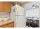 Retro kitchen with wood cabinets, white appliances and a view of dining area at 10125 W 25Th Ave # 47, Lakewood, CO 80215