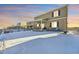 Backyard with patio, string lights, and snow on the ground at 1867 Homestead Dr, Fort Lupton, CO 80621
