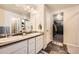 Well-lit bathroom featuring a double sink vanity, modern fixtures, and a view into a spacious walk-in closet at 1867 Homestead Dr, Fort Lupton, CO 80621