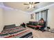 This cozy bedroom features neutral walls, a ceiling fan, and a futon for extra seating at 1867 Homestead Dr, Fort Lupton, CO 80621