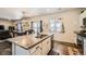 Open concept kitchen with island and granite countertops, view into dining area at 1867 Homestead Dr, Fort Lupton, CO 80621