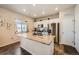 Bright kitchen with white cabinets, granite countertops, stainless steel appliances and a kitchen island at 1867 Homestead Dr, Fort Lupton, CO 80621