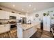 Well-lit kitchen featuring a central island with granite countertop and modern stainless steel appliances at 1867 Homestead Dr, Fort Lupton, CO 80621