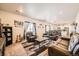 Spacious living room featuring leather sofas, a coffee table, and a view into the kitchen at 1867 Homestead Dr, Fort Lupton, CO 80621