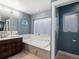 Bathroom with soaking tub, double windows and a dark wood vanity at 4571 Stuart St, Denver, CO 80212