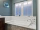 Close up of soaking tub with subway tile surround and quartz countertops at 4571 Stuart St, Denver, CO 80212