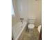 Bathroom featuring a white bathtub, toilet, and tile walls at 8353 Gaylord St, Denver, CO 80229