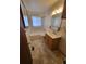 Cozy bathroom features tiled floors, a wooden vanity, and a combined shower and bathtub, offering practical comfort at 8353 Gaylord St, Denver, CO 80229