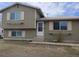 Split-level home features white trim, neutral siding and a concrete walk-up entrance, offering classic curb appeal at 8353 Gaylord St, Denver, CO 80229