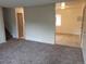 Open living area features neutral walls and carpeting, flowing seamlessly into a kitchen and dining space at 8353 Gaylord St, Denver, CO 80229