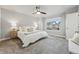 Bright bedroom features plush carpet, ceiling fan, neutral decor and large window at 15628 W Baker Ave, Lakewood, CO 80228