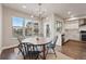 Bright dining area with hardwood floors, view of kitchen, and contemporary lighting at 15628 W Baker Ave, Lakewood, CO 80228