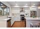Modern kitchen with stainless steel appliances, white cabinets, and eat-in island at 15628 W Baker Ave, Lakewood, CO 80228
