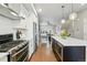 Contemporary kitchen with stainless appliances and island with seating and microwave at 15628 W Baker Ave, Lakewood, CO 80228