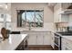 Bright kitchen featuring white cabinetry, stainless steel appliances, and a garden view at 15628 W Baker Ave, Lakewood, CO 80228