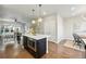 Open concept kitchen with island, seating, stainless appliances and hardwood floors adjacent to dining area at 15628 W Baker Ave, Lakewood, CO 80228