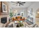 Cozy living room with a stone fireplace, modern furnishings, and a ceiling fan at 15628 W Baker Ave, Lakewood, CO 80228