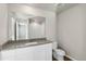 Bathroom featuring a large mirror and white cabinets with gray countertop at 3003 Pershing St, Strasburg, CO 80136