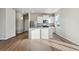 Modern kitchen featuring white cabinets, stainless steel appliances and hardwood floors at 3003 Pershing St, Strasburg, CO 80136