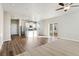 Bright, open-concept living room featuring hardwood floors, ceiling fan and sliding glass doors at 3003 Pershing St, Strasburg, CO 80136