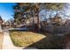 Backyard with grassy area, trees, and a wooden fence at 6620 E Virginia Ave, Denver, CO 80224