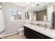 Updated bathroom with double vanity, shower, and neutral tile at 6620 E Virginia Ave, Denver, CO 80224