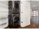 Convenient laundry room with stackable washer and dryer and shelving at 6620 E Virginia Ave, Denver, CO 80224