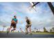 Community basketball court features two young men playing a game in the summer evening air at 27604 E Byers Ave, Aurora, CO 80018