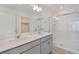 Bright bathroom featuring double sinks, quartz countertops, glass enclosed shower, and walk-in closet at 27604 E Byers Ave, Aurora, CO 80018