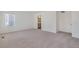 Bright carpeted bedroom featuring a window and doorway to a bathroom at 27604 E Byers Ave, Aurora, CO 80018