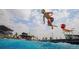 Community pool features a young boy jumping into the clear water with a modern clubhouse in the background at 27604 E Byers Ave, Aurora, CO 80018