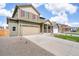 View of a two-story home with two car garage, stone landscaping, and a spacious driveway at 27604 E Byers Ave, Aurora, CO 80018