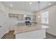 A kitchen features a central island with granite countertops, pendant lighting, stainless steel appliances, and gray cabinetry at 27604 E Byers Ave, Aurora, CO 80018