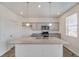 A kitchen features a central island with granite countertops, pendant lighting, stainless steel appliances, and gray cabinetry at 27604 E Byers Ave, Aurora, CO 80018