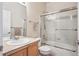 Bright bathroom featuring a shower-tub combo with sliding glass door and neutral color scheme at 21063 E Greenwood Pl, Aurora, CO 80013