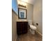 This bathroom features a cherry vanity, a decorative mirror and a standard toilet at 1836 E Mineral Ave, Centennial, CO 80122