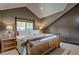 Comfortable bedroom features a wooden frame bed, two bedside tables, and sloped ceilings at 185 S Fuller Placer Rd, Breckenridge, CO 80424