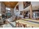 Open-concept living and dining area with a stone fireplace, wood beams, and a large dining table at 185 S Fuller Placer Rd, Breckenridge, CO 80424